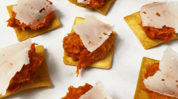 Toketti crackers topped with 'Nduja and a shaving of Naked Goat cheese