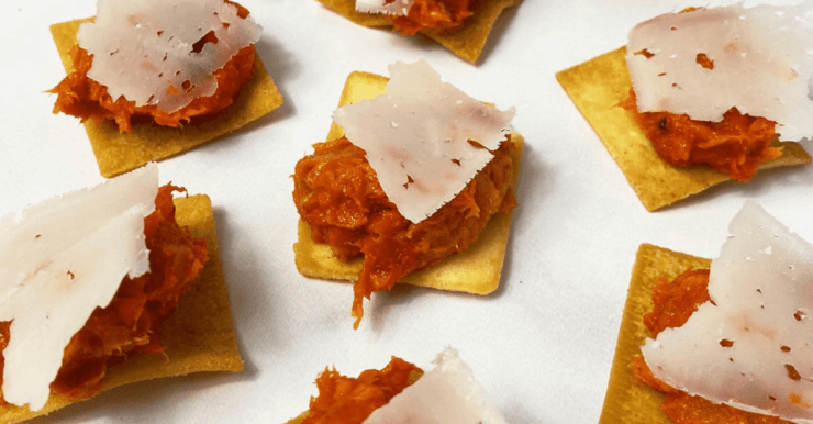 Toketti crackers topped with 'Nduja and a shaving of Naked Goat cheese